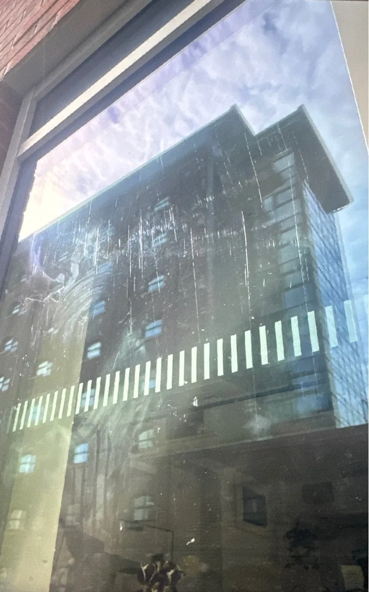 Commercial window glass in Edinburgh before restoration, showing extensive scratches