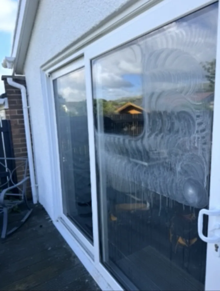 Patio door glass in St Andrews during polishing, with a polished transparent section beside areas still being treated