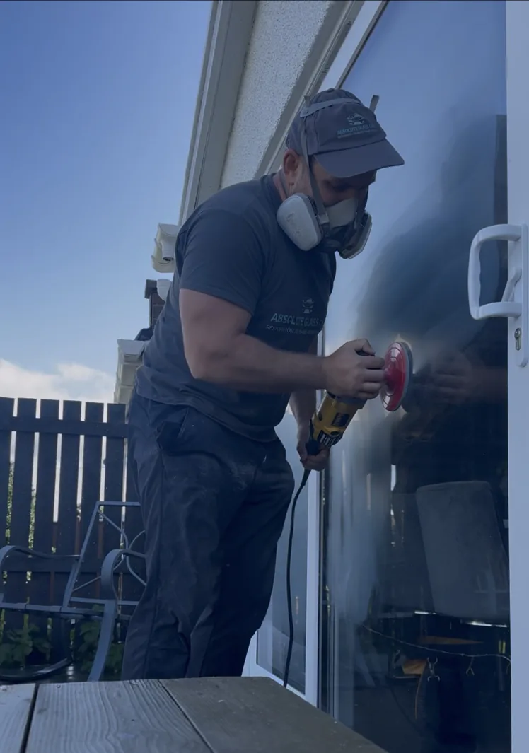 Absolute Glass Care specialist using glass restoration equipment on sliding patio door glass at a home in St Andrews