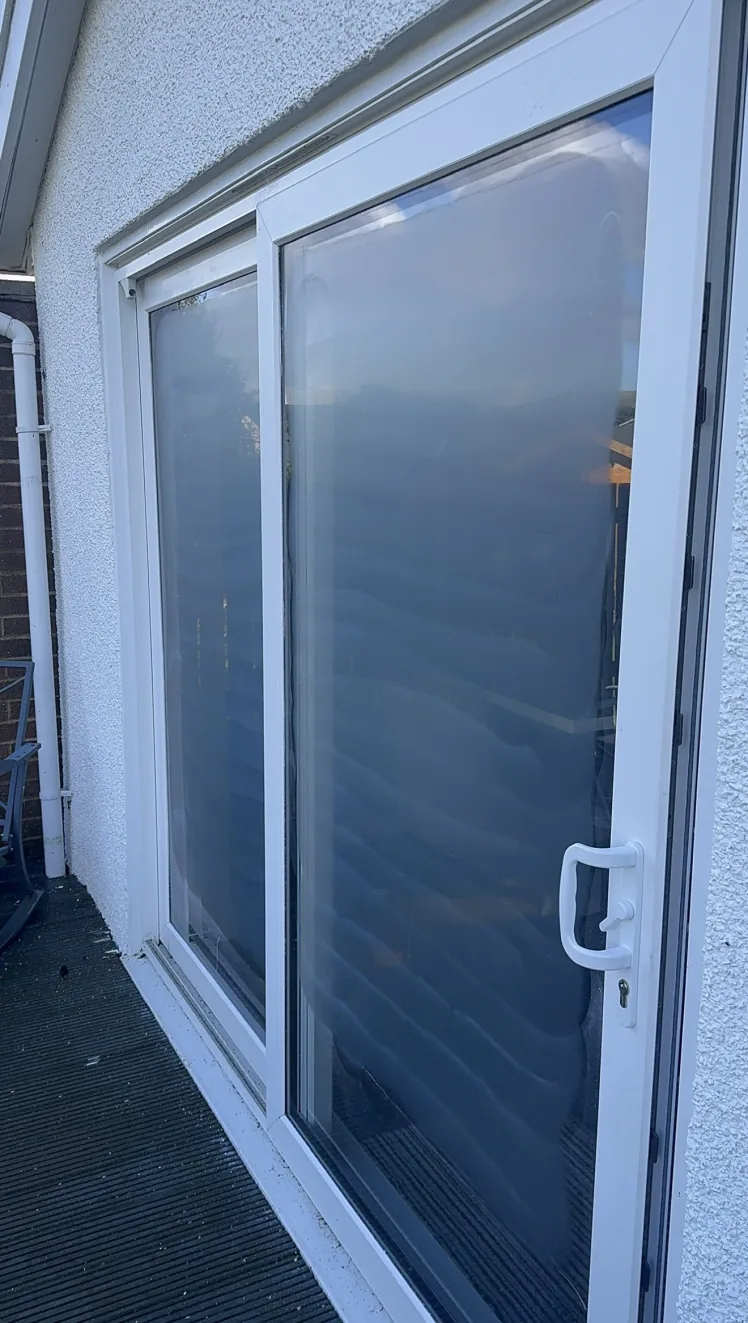 Two sliding patio door glass panels in St Andrews showing the temporary matte finish of the surface refinement stage