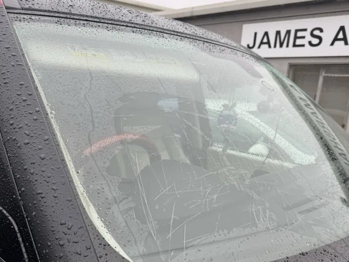Windscreen with deep surface scratches concentrated in driver view area before restoration