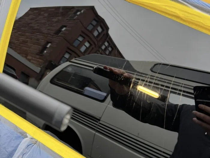 Car window glass with visible fine scratch lines from vandalism before restoration