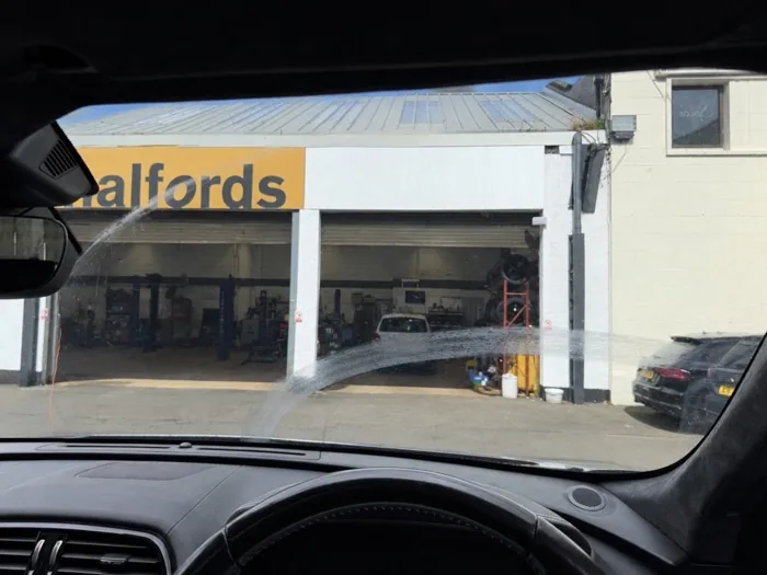 Windscreen with visible wiper-arc scratches before restoration